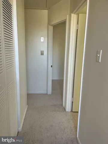 a view of an empty room with closet and mirror