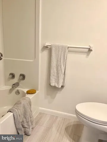 a bathroom with a white toilet and a shower curtain