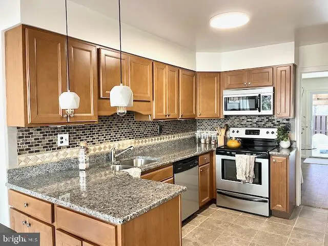 a kitchen with stainless steel appliances granite countertop a sink a stove and a microwave