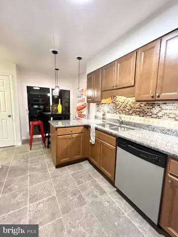 a kitchen with a sink a counter top space cabinets stainless steel appliances and a window