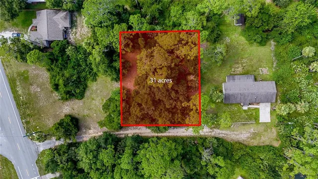an aerial view of residential house with outdoor space and trees all around