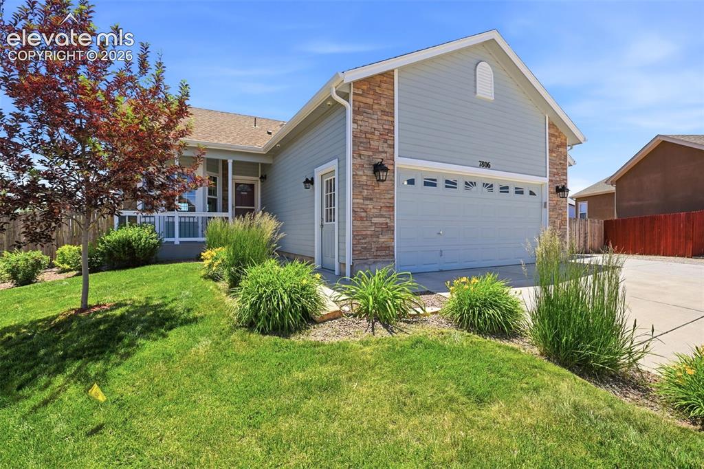 7806 Dutch Loop Colorado Springs, CO 80925 - Photo 2 of 41 a view of a house with a yard and plants