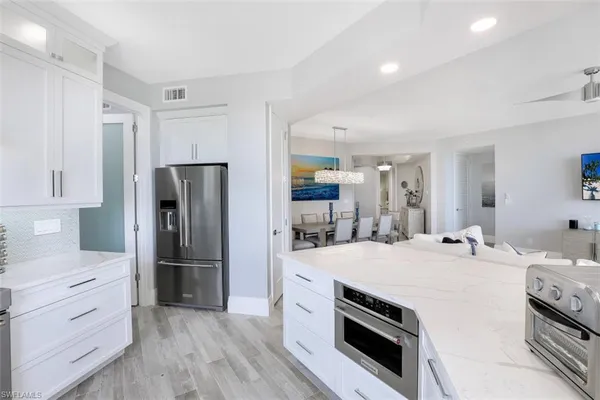 a kitchen with a refrigerator and a stove top oven