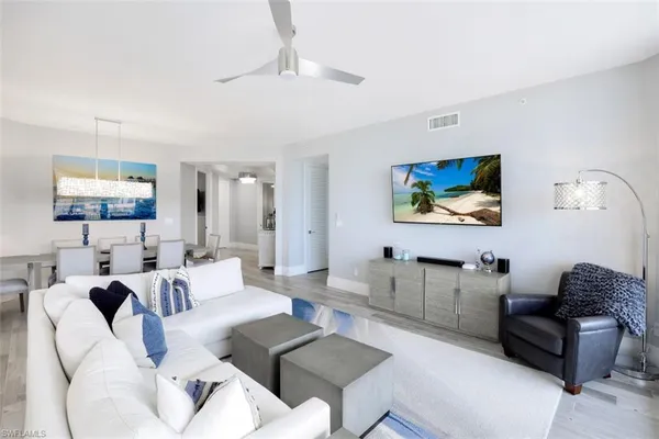 a living room with furniture a couch and paintings on the wall