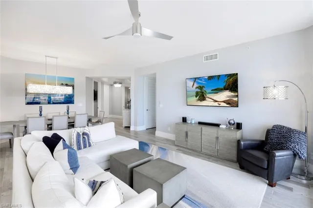 a living room with furniture a couch and paintings on the wall