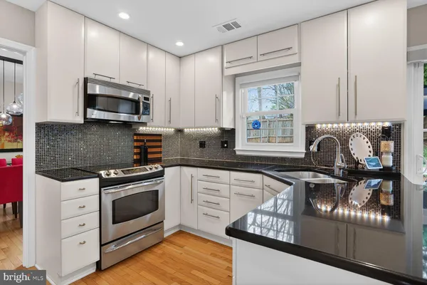 a kitchen with stainless steel appliances granite countertop a stove sink and microwave