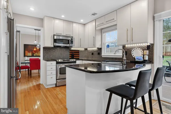a kitchen with stainless steel appliances kitchen island granite countertop a sink and cabinets