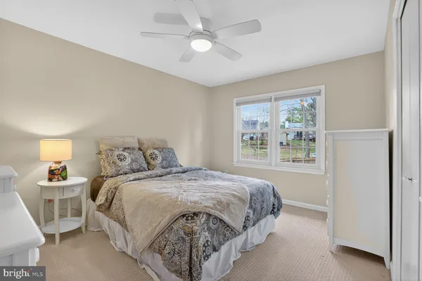 a bedroom with a large bed and a chandelier fan