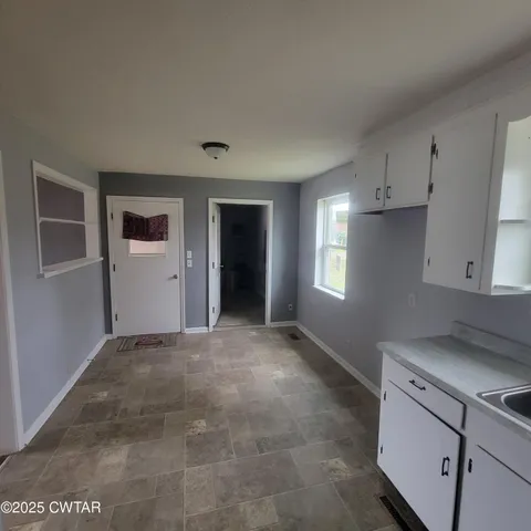 a view of an empty room with a kitchen