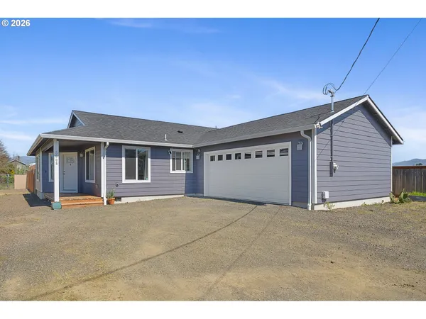 a view of an house with backyard and a garage