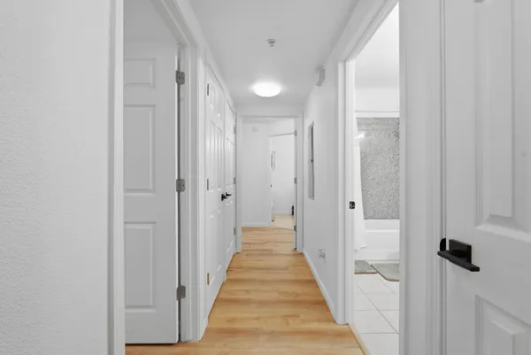 a view of a hallway with wooden floor and staircase
