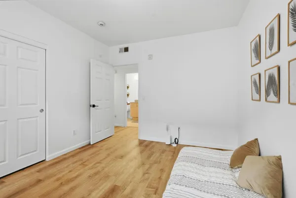 a bedroom with a bed and wooden floor