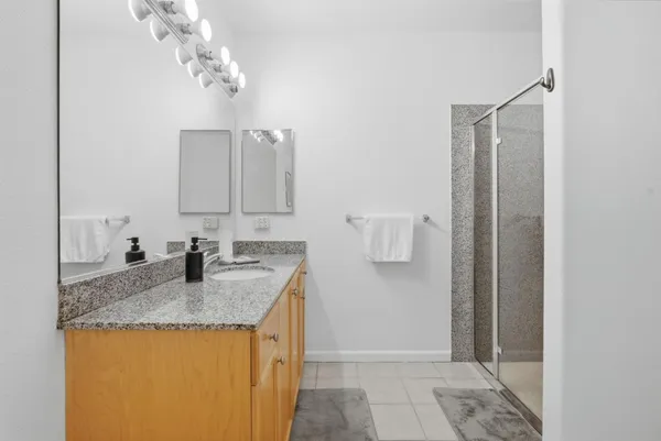 a bathroom with a granite countertop sink and a mirror