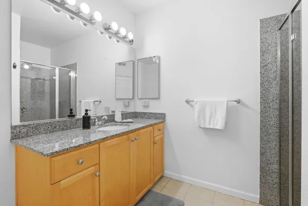 a bathroom with a granite countertop sink and a mirror