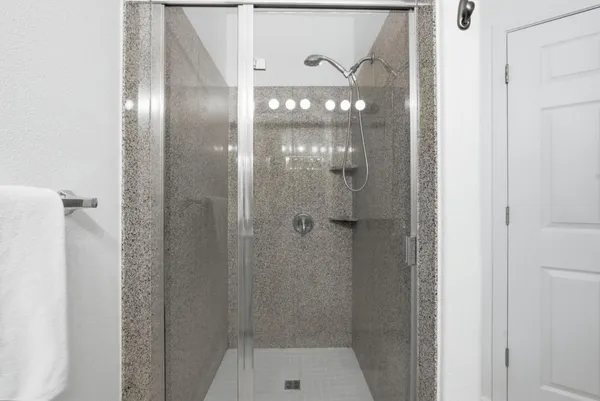 a bathroom with a glass shower door and a mirror