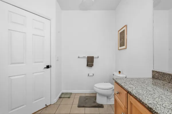 a bathroom with a granite countertop toilet and a sink