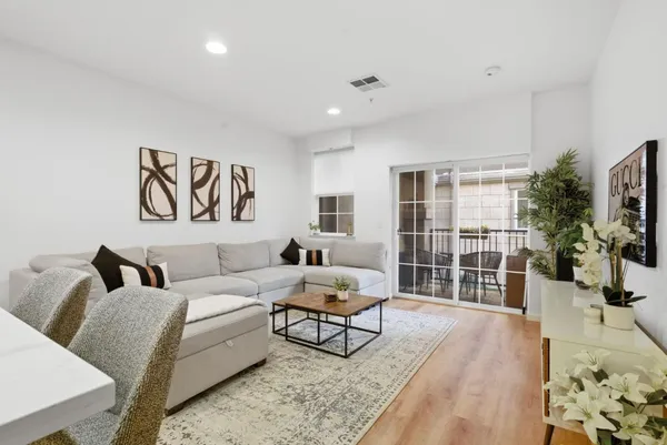 a living room with furniture a flat screen tv and a large window