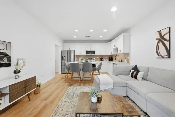 a living room with furniture kitchen view and a table