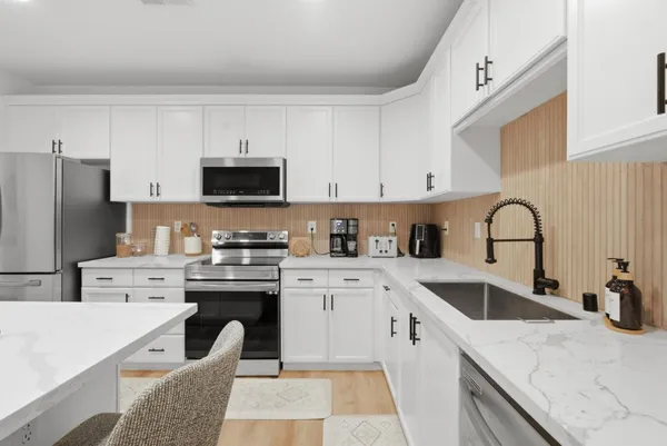 a kitchen with stainless steel appliances granite countertop a sink a stove and refrigerator