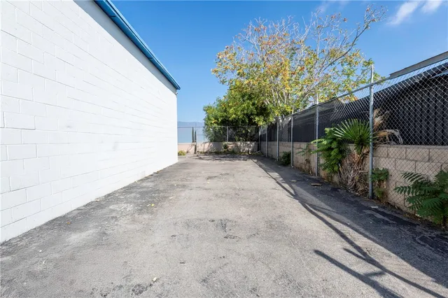a view of a backyard with potted plants and wooden fence