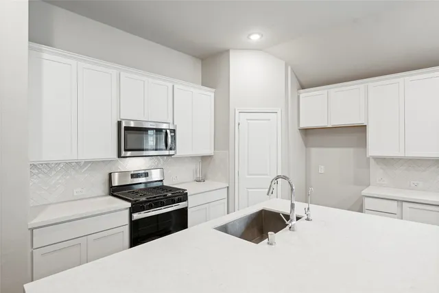 a kitchen with a sink stove and refrigerator