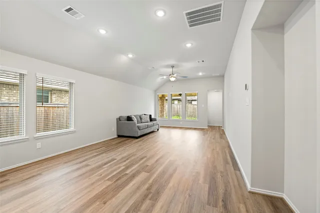 a spacious bedroom with a bed and a ceiling fan