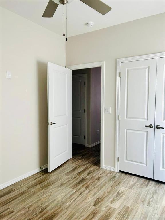 4904 North Crown Point, Unit 1 Pharr, TX 78577 - Photo 16 of 22 an empty room with wooden floor a ceiling fan and windows