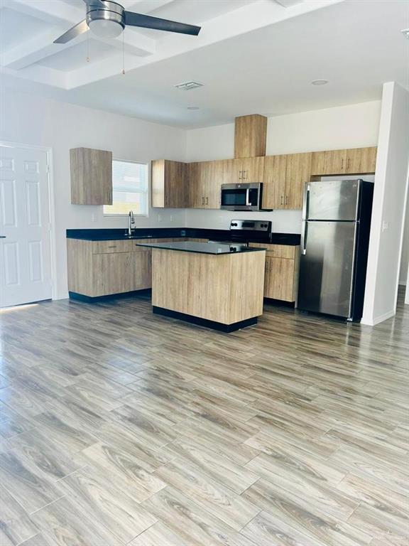 4904 North Crown Point, Unit 1 Pharr, TX 78577 - Photo 8 of 22 a kitchen with stainless steel appliances kitchen island wooden floors granite counter tops and white cabinets