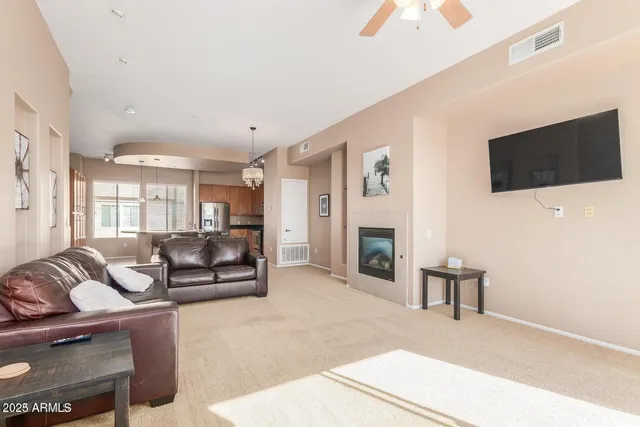 a living room with furniture a fireplace and a flat screen tv