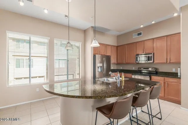 a kitchen with stainless steel appliances granite countertop a stove top oven a refrigerator a sink and a granite counter tops