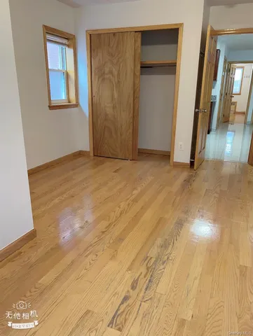 a view of a hallway with wooden floor and closet