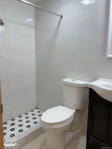 a white toilet sitting next to a white sink and vanity