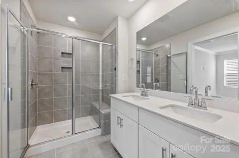 a bathroom with a shower sink vanity and mirror