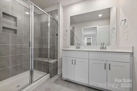 a bathroom with a shower sink and mirror