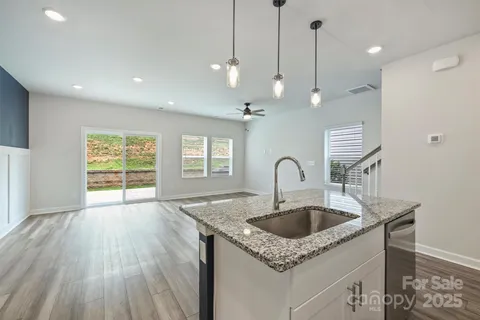 a kitchen with a sink a faucet a chandelier and wooden floor