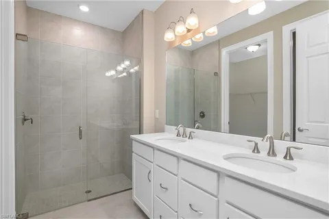 a bathroom with double sink and a mirror