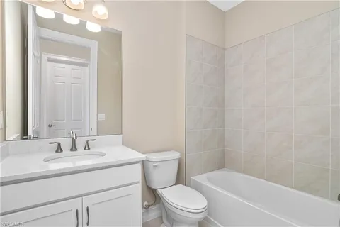 a bathroom with a granite countertop sink a toilet and shower
