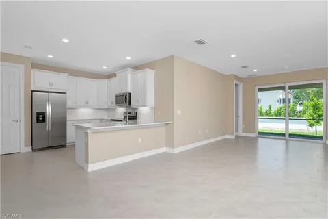 a large kitchen with stainless steel appliances granite countertop a refrigerator and a sink