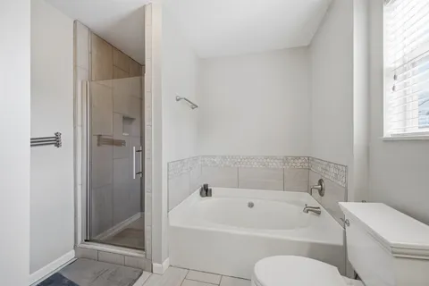 a white bath tub sitting next to a white toilet