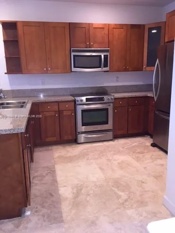 a kitchen with stainless steel appliances granite countertop a stove microwave and sink