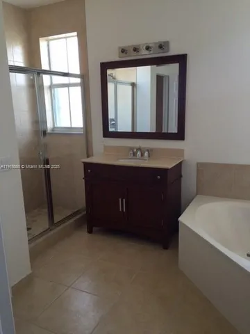 a bathroom with a tub a sink and a mirror