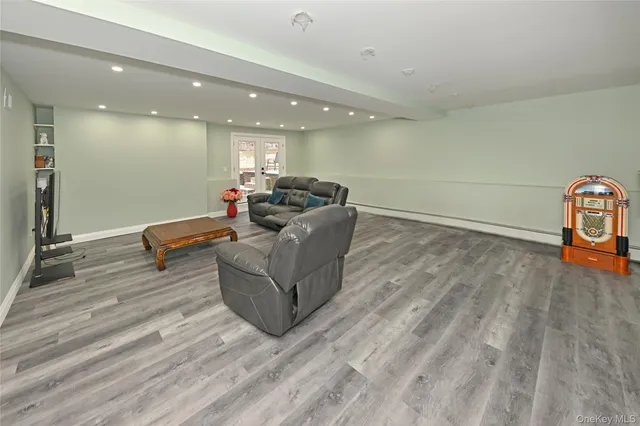 a living room with couches and kitchen view with wooden floor