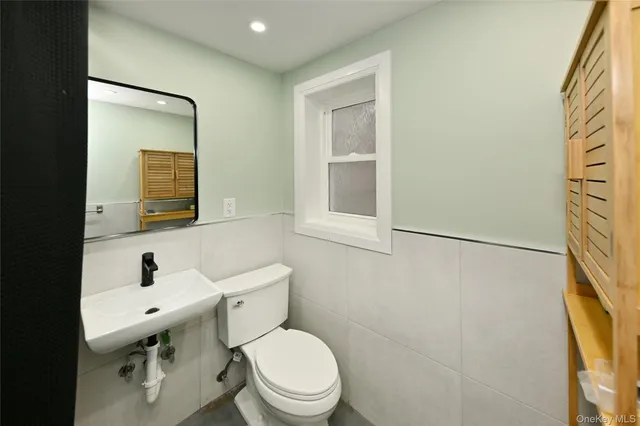 a bathroom with a toilet a sink and mirror