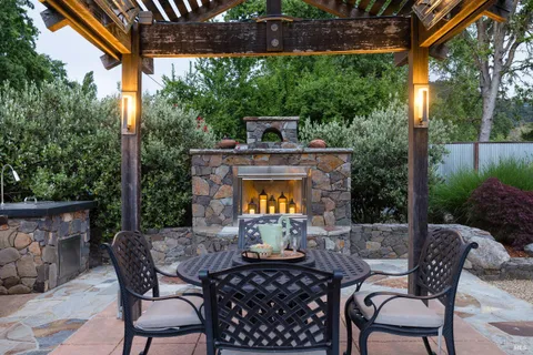 a view of a patio with a table chairs and a fire pit