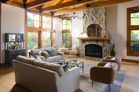 a living room with furniture a fireplace and a floor to ceiling window
