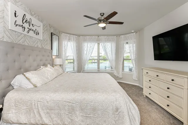 a bedroom with a large bed and a flat screen tv