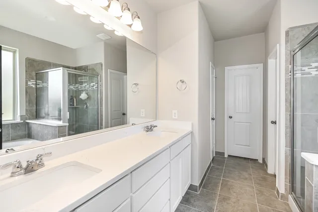 a spacious bathroom with a sink a mirror and a shower