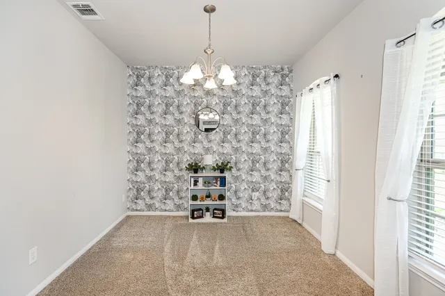 a view of a hallway with windows and chandelier