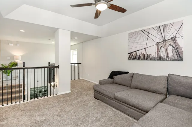 a living room with furniture and ceiling fan