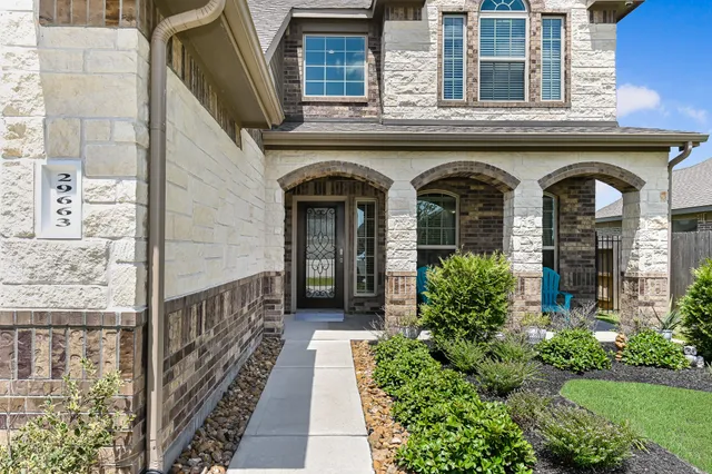 a front view of a house with glass windows and yard